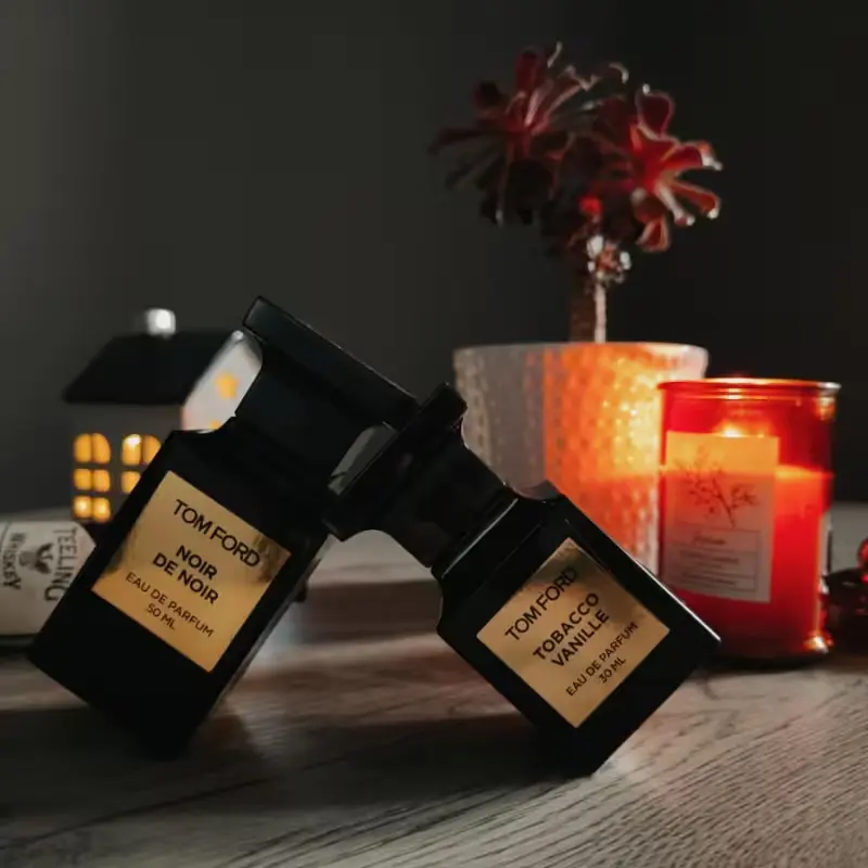 Perfume Tobacco Vanille de Tom Ford ao lado do Noir de Noir em um ambiente elegante, simbolizando sua versatilidade e luxo.